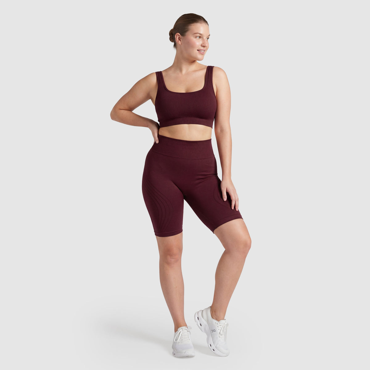 Woman wearing Sculpt 3D™ anti-cellulite shorts in plum, front view, high-waisted fit
