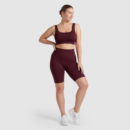 Woman wearing Sculpt 3D™ anti-cellulite shorts in plum, front view, high-waisted fit