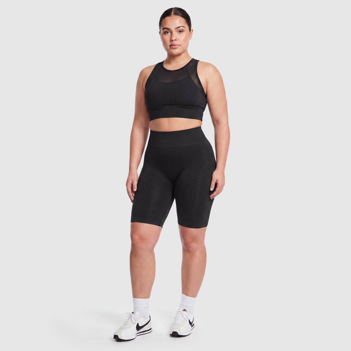 Woman wearing Sculpt 3D™ anti-cellulite shorts in black, front view, high-waisted fit