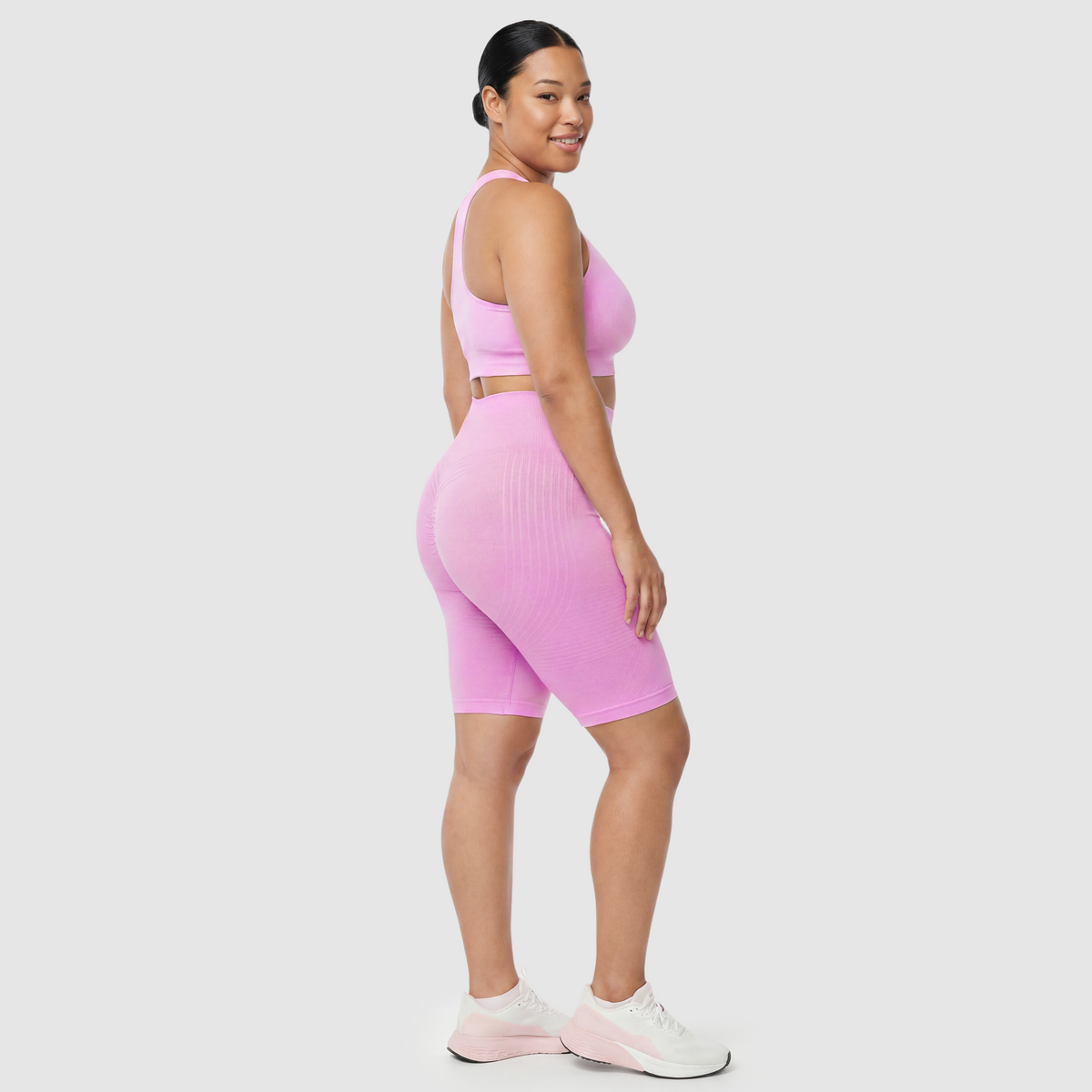 Woman wearing Sculpt 3D™ anti-cellulite shorts in pink, side view, showing the 3D sculpt lines