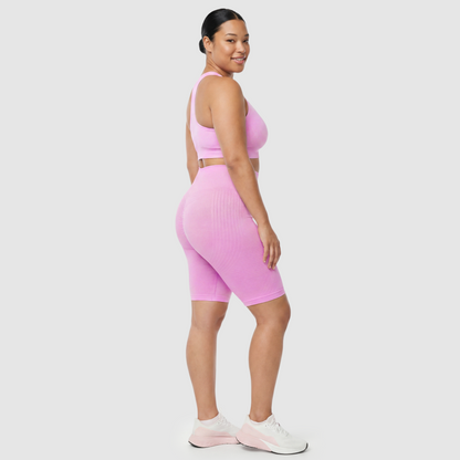 Woman wearing Sculpt 3D™ anti-cellulite shorts in pink, side view, showing the 3D sculpt lines