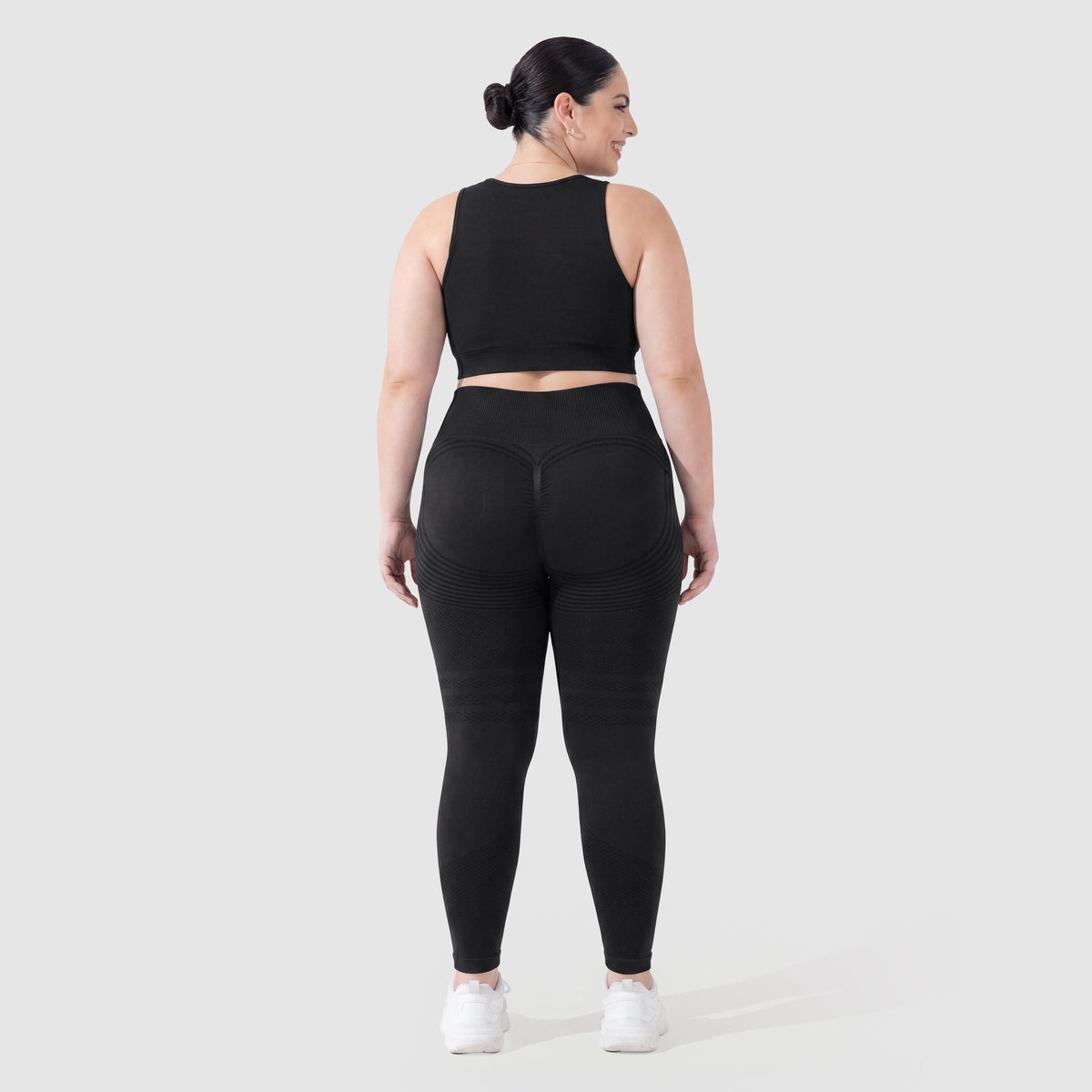 Woman wearing Sculpt 3D™ anti-cellulite leggings in black, back view, lifted, contoured rear