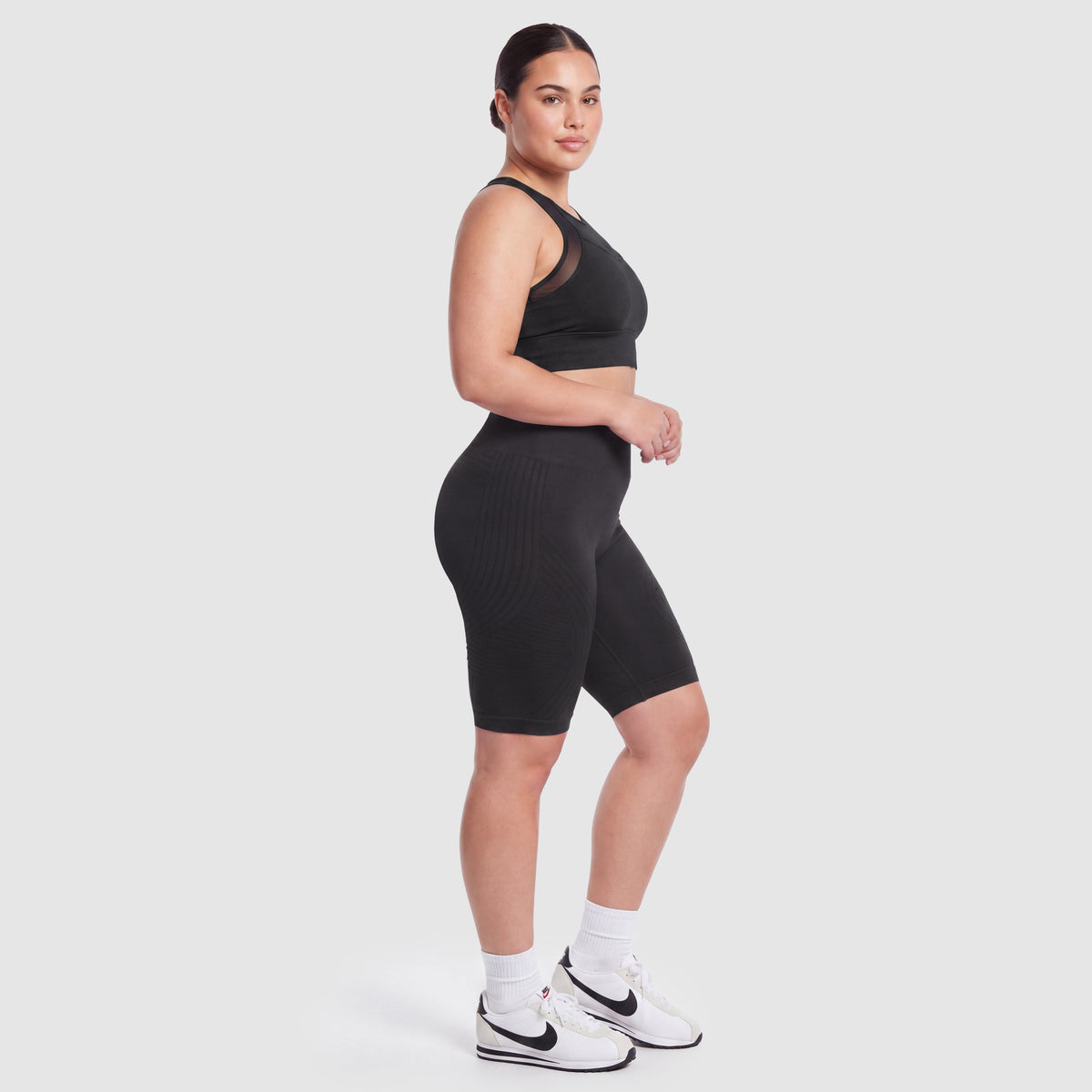 Woman wearing Sculpt 3D™ anti-cellulite shorts in black, side view, showing the 3D sculpt lines