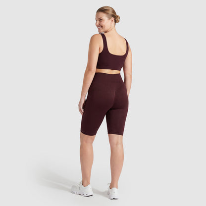 Woman wearing Sculpt 3D™ anti-cellulite shorts in plum, back view, lifted, contoured rear