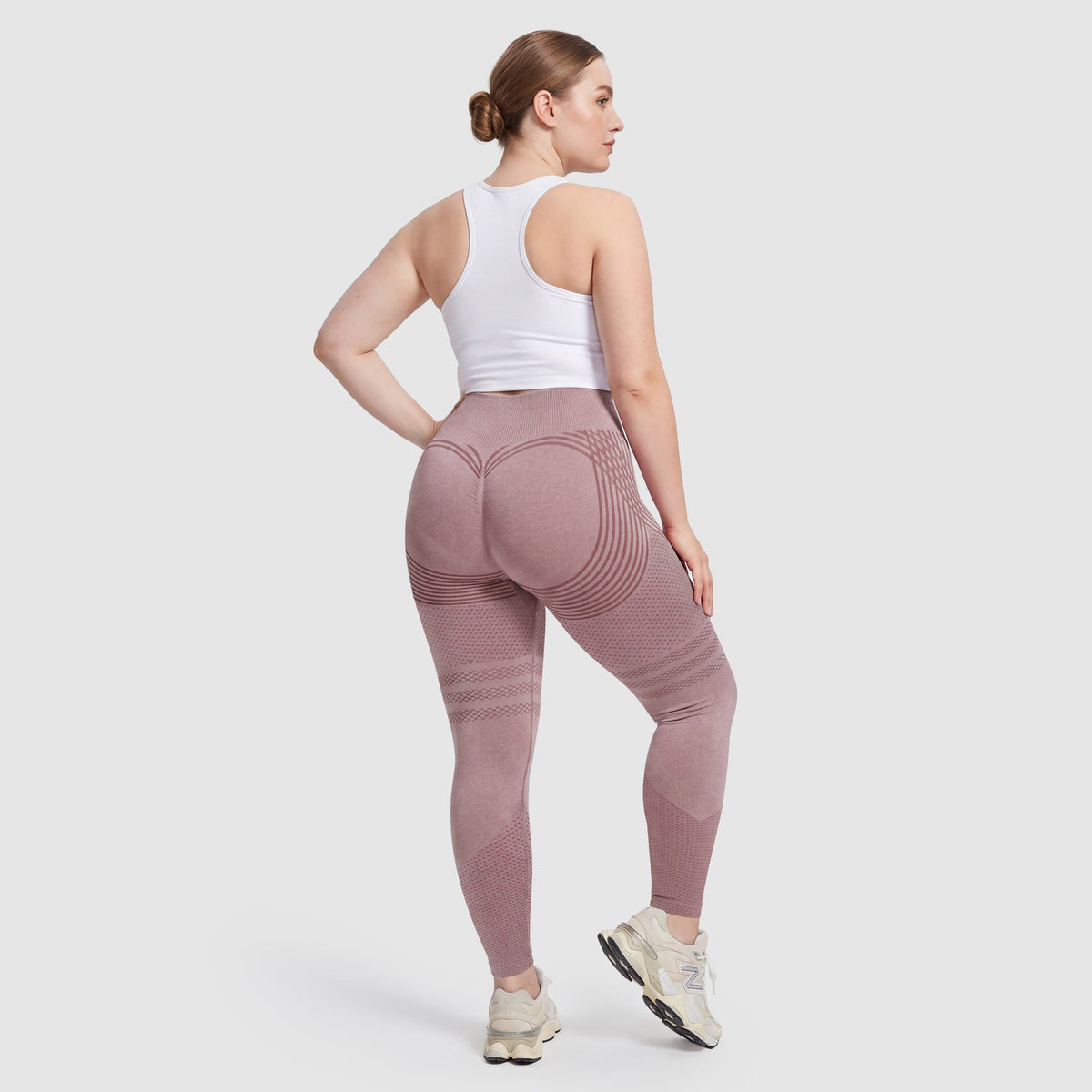 Woman wearing Sculpt 3D™ anti-cellulite leggings in pink, back view, lifted, contoured rear