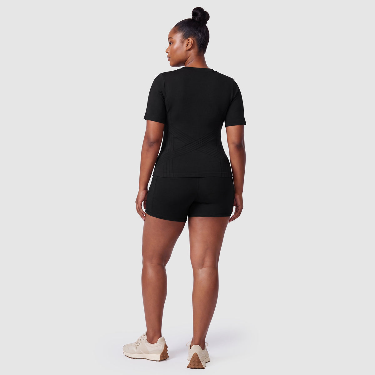 Woman wearing the Sculpt 3D™ compression tee in black, back view