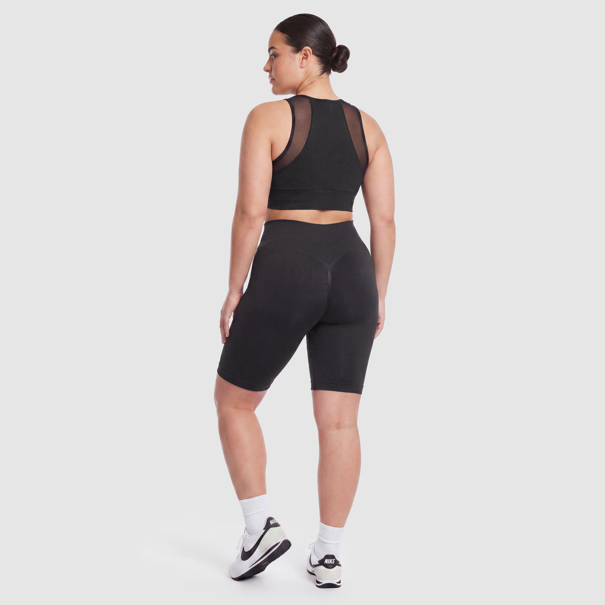 Woman wearing Sculpt 3D™ anti-cellulite shorts in black, back view, lifted, contoured rear