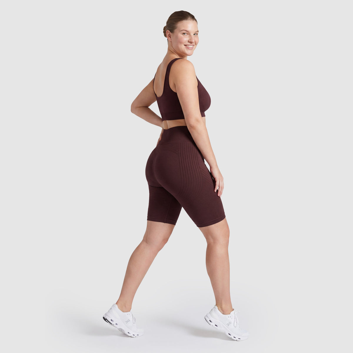 Woman wearing Sculpt 3D™ anti-cellulite shorts in plum, side view, showing the 3D sculpt lines