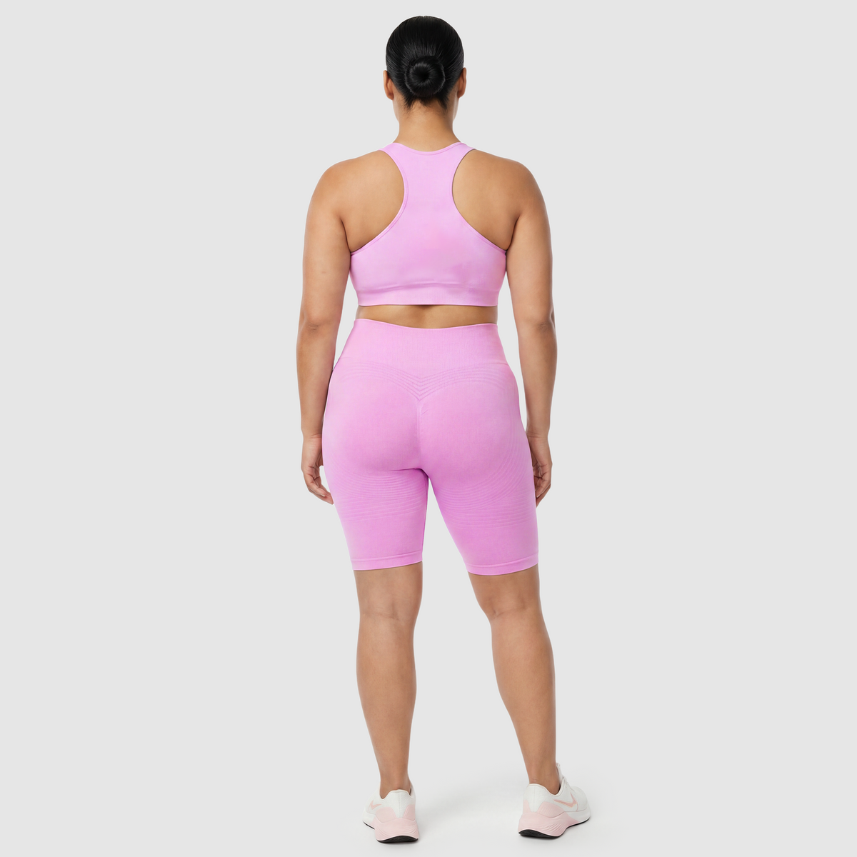 Woman wearing Sculpt 3D™ anti-cellulite shorts in pink, back view, lifted, contoured rear