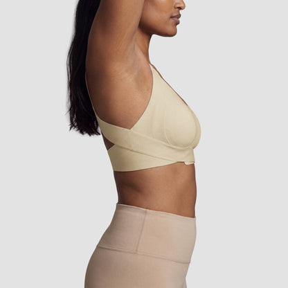 Sculpt posture bra in beige, side view with arm raised to show the wireless fit