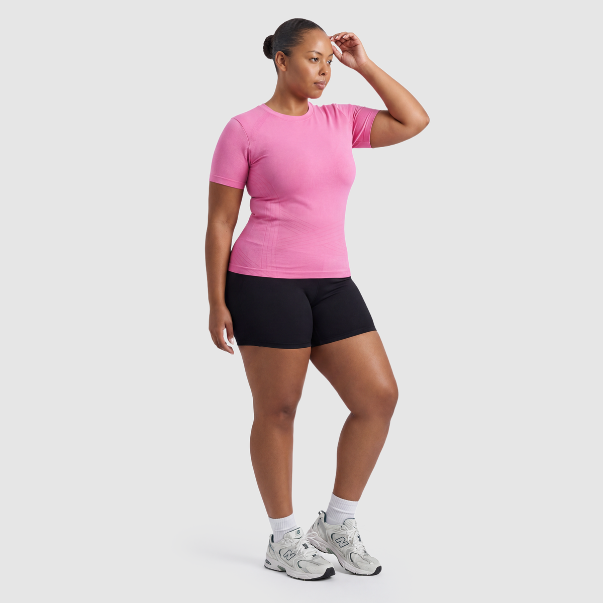 Woman wearing the Sculpt 3D™ compression tee in pink, three-quarter view