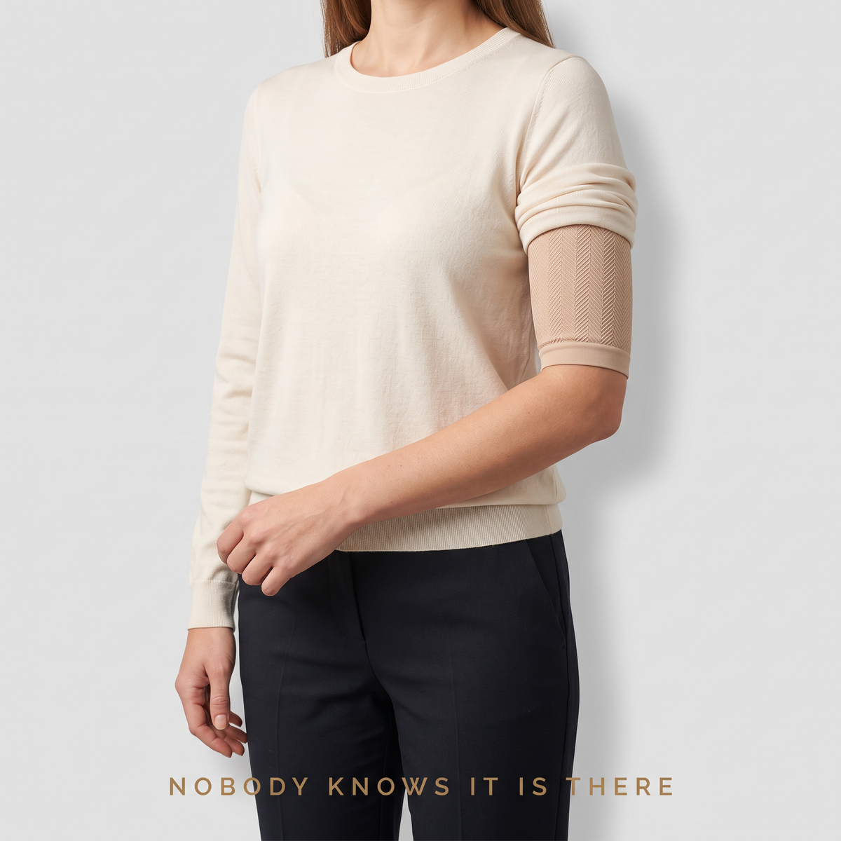 Beige Sculpt™ compression arm sleeve worn discreetly under a cream sweater